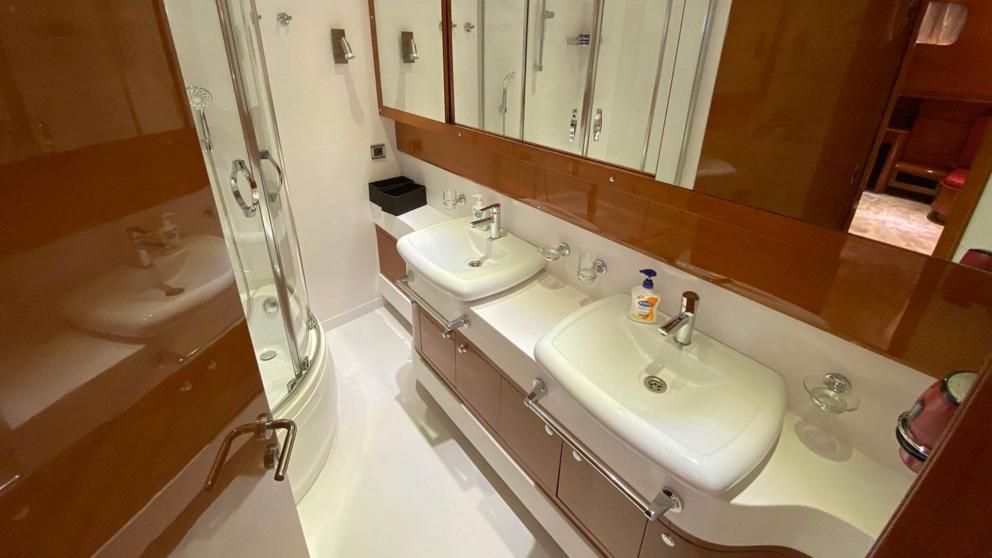 Ванная комната гулеты Gül Maria. Можно увидеть 2 раковины и душевую кабину и ящики с зеркалами